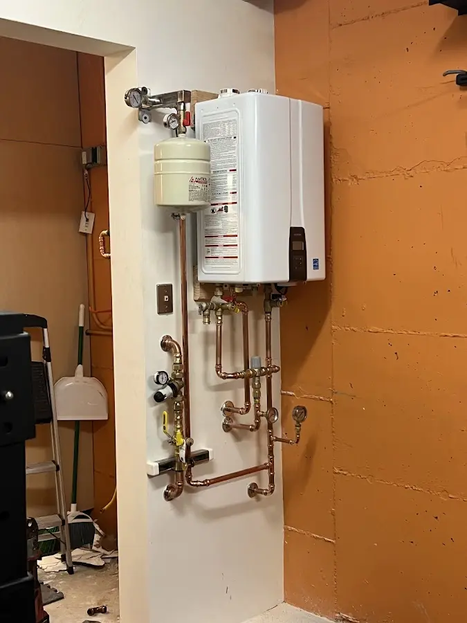 Plumbing technician inspecting water heater connections in Ferndale